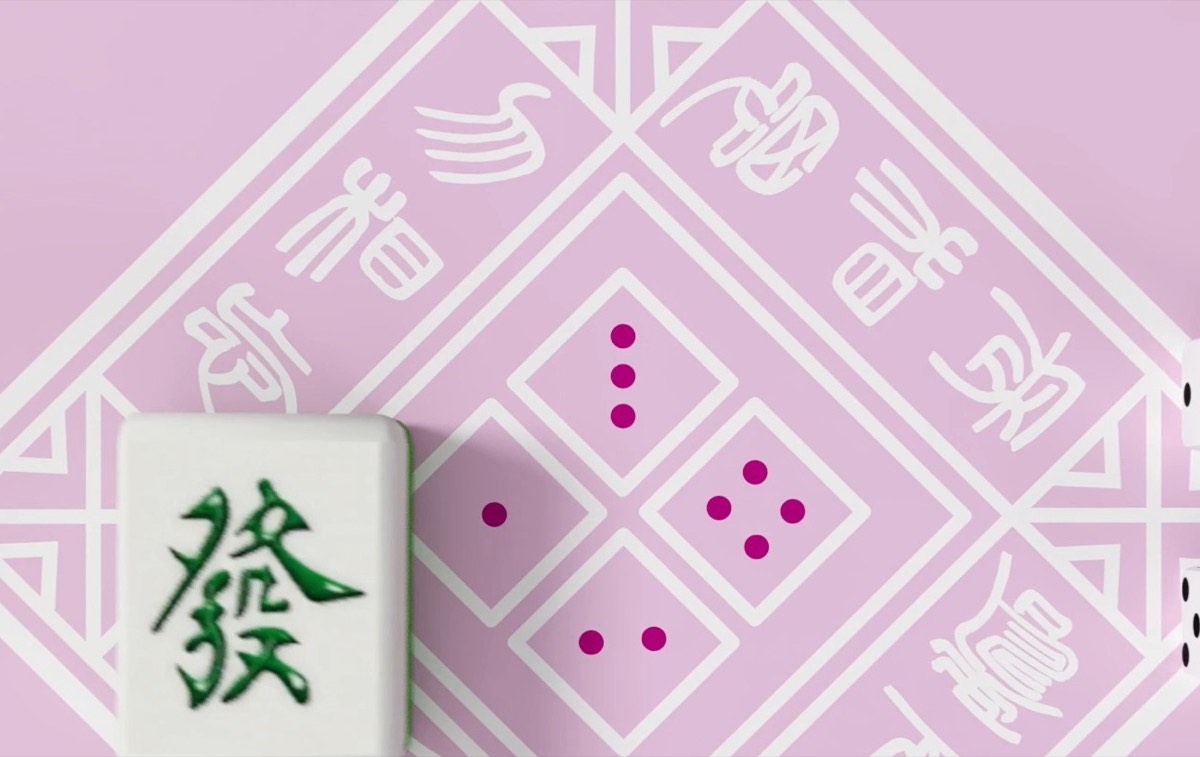 Mahjong tile and dice resting on the smooth fabric surface of the mat